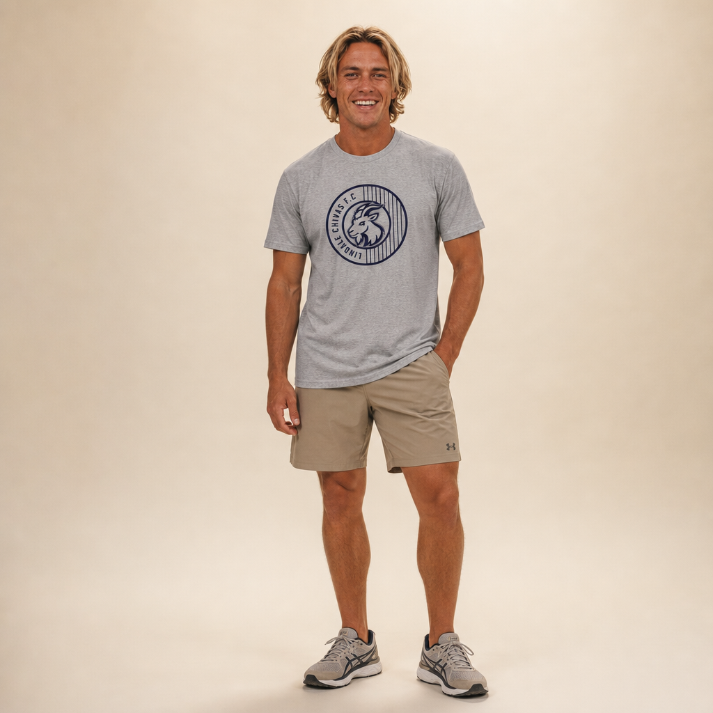 Man wearing the Lindale Chivas Soccer Logo Tee in Premium Heather, worn untucked over tan shorts