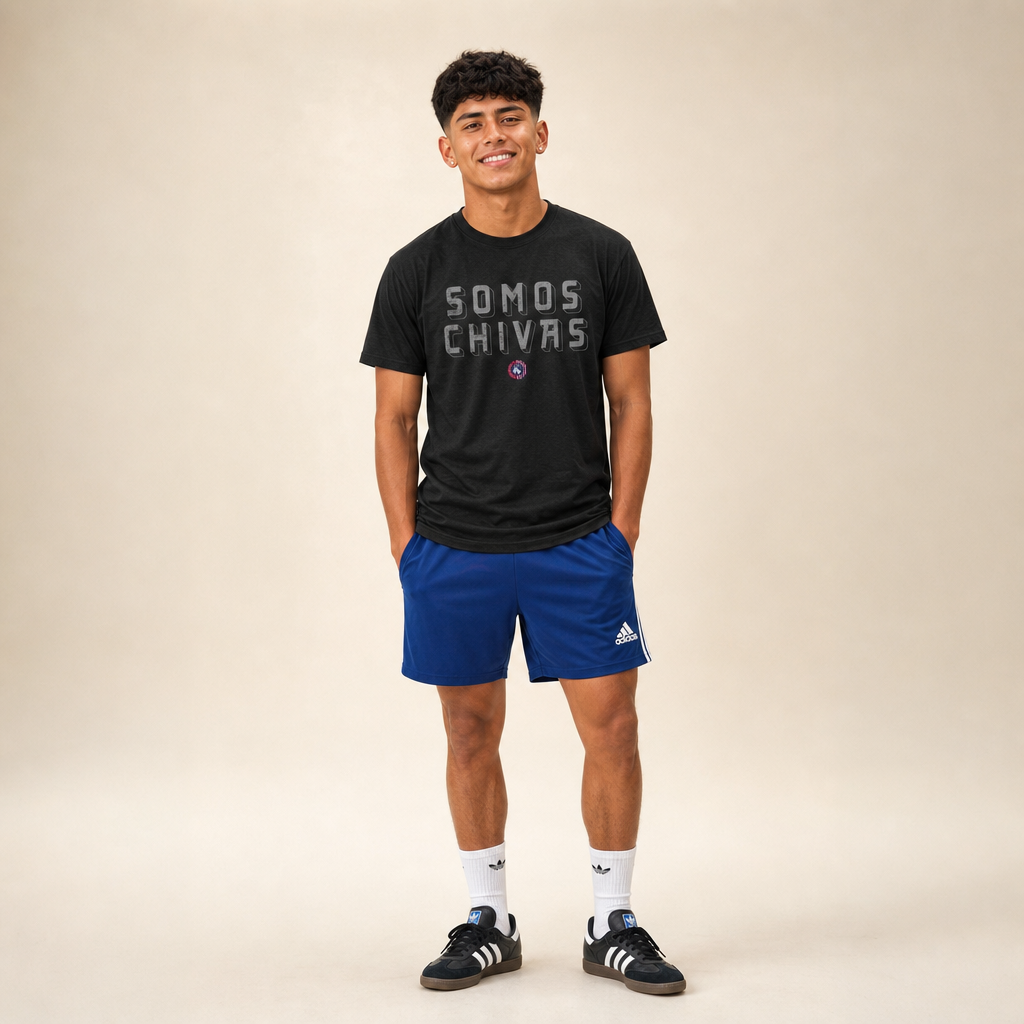 Soccer player wearing the Lindale Chivas Somos Chivas Tee in Black, worn untucked over royal blue soccer shorts with Adidas Sambas