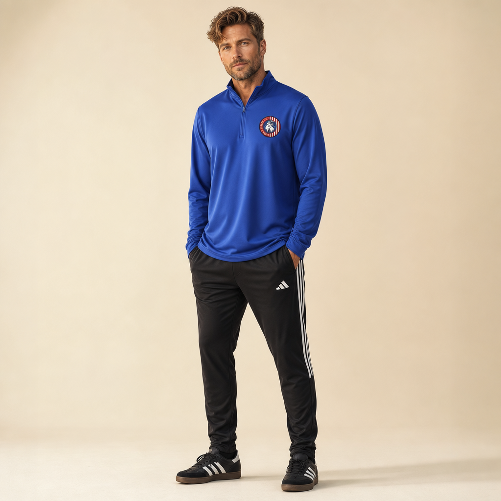 Man wearing the Lindale Chivas Quarter-Zip Pullover in Red, worn untucked over soccer pants with Adidas Sambas