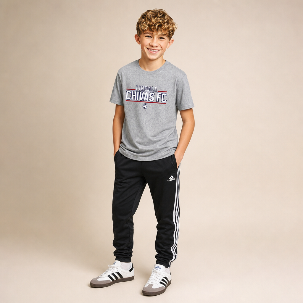 Boy wearing the Lindale Chivas Wordmark Youth Tee in Navy Triblend with Adidas soccer pants and Sambas