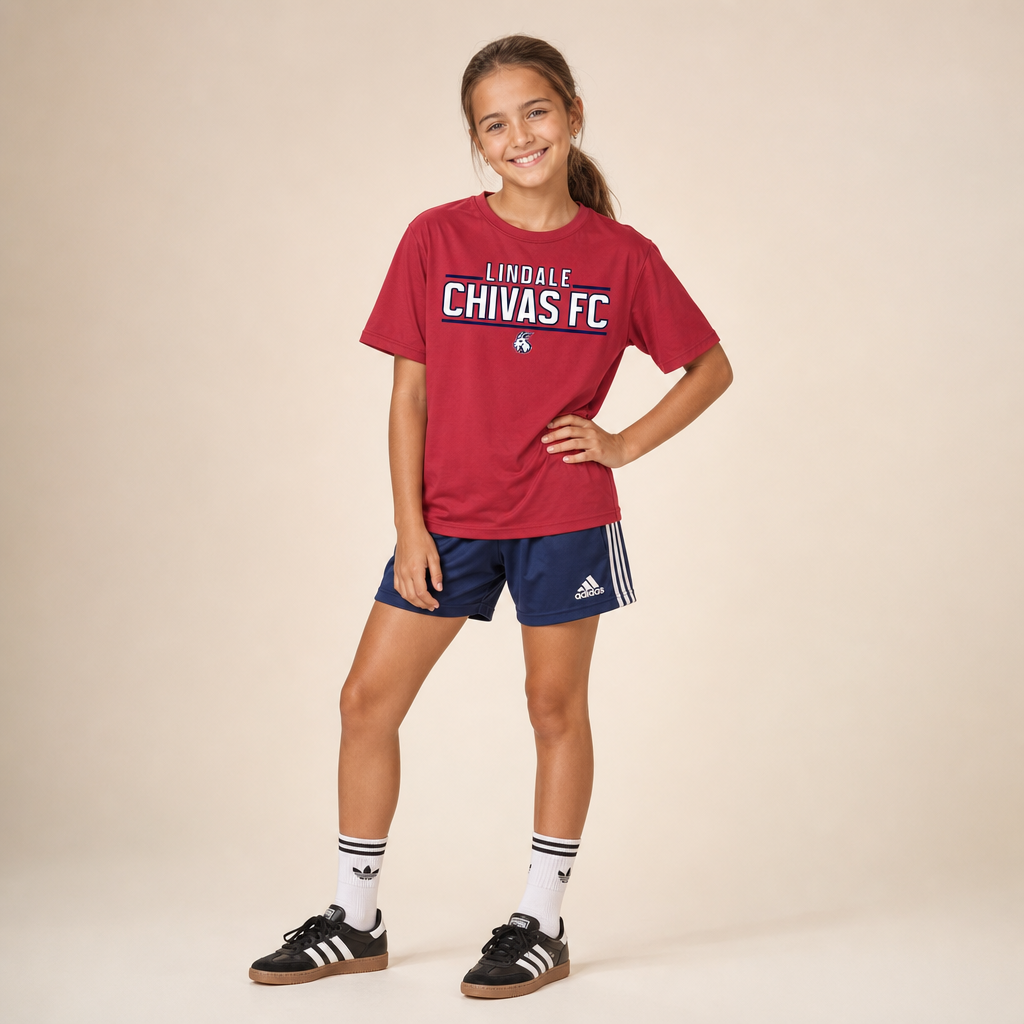 Girl wearing the Lindale Chivas Youth Dri-Fit Tee in True Red with blue Adidas soccer shorts and Sambas