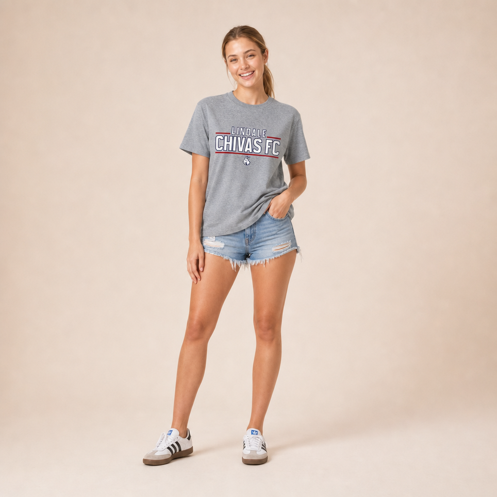 Woman wearing the Lindale Chivas Wordmark Tee in Premium Heather with distressed jean shorts and Adidas Sambas